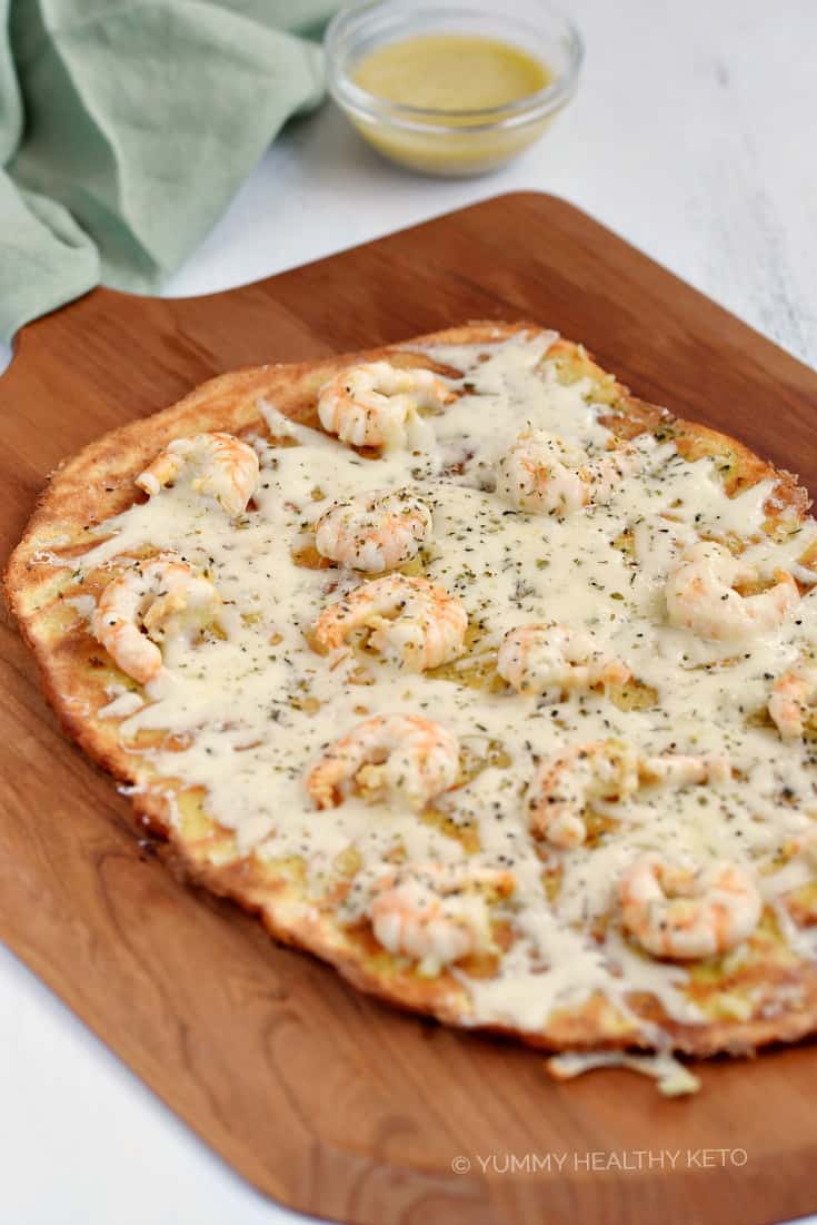 A keto Shrimp Scampi Pizza on a wooden pizza peel